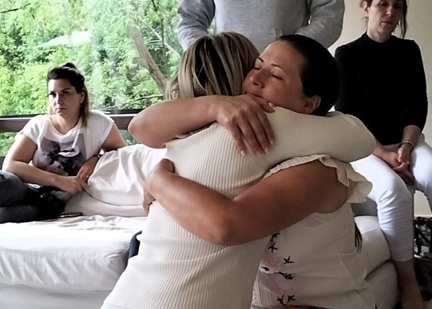 Îmbrățișare emoțională între participantele unui retreat al Academiei Călătorie către Sine