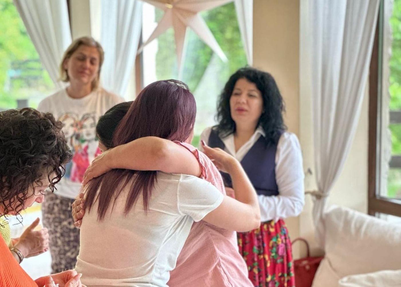Îmbrățișare plină de emoție între participantele unui retreat al Academiei Călătorie către Sine